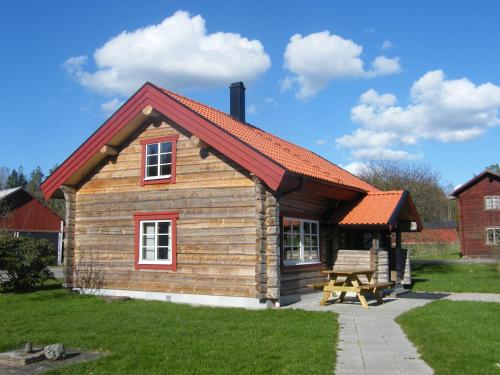 a small log cabin with a red roof at Fårgården Åsebol in Gårdsjö