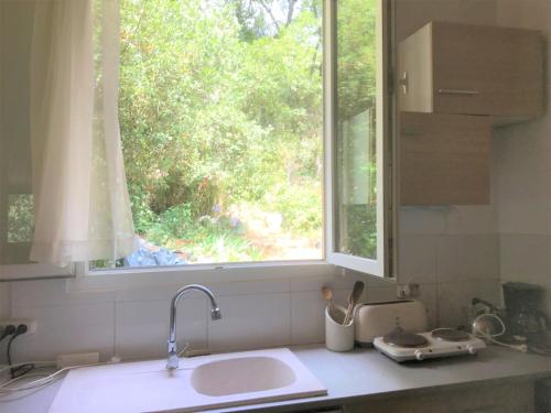 a kitchen counter with a sink and a window at Chalet dans Résidence Privée in La Gaude