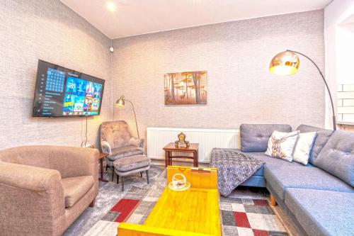 sala de estar con sofá y TV en Spacious 5 Bed House, perfect for groups, great location, en Liverpool