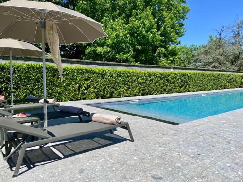 a chair and an umbrella next to a swimming pool at Living Hotel Milano in Cornaredo