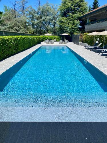 a swimming pool with blue water in a yard at Living Hotel Milano in Cornaredo