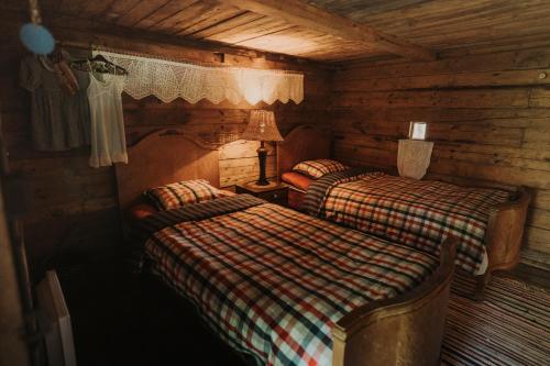 a bedroom with two beds in a log cabin at Muhu Tõnise Talu in Liiva