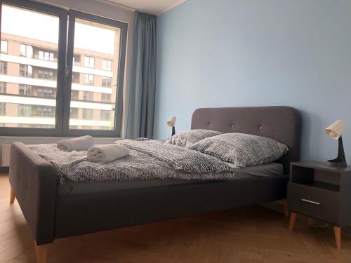 - une chambre avec un lit et une grande fenêtre dans l'établissement Plac Unii Apartments, à Gdynia