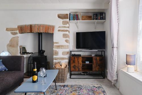 a living room with a couch and a tv at Finest Retreats - Primrose Cottage in Tywardreath