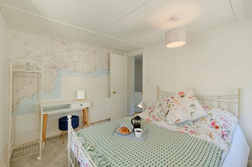 a bedroom with a bed with a map on the wall at Finest Retreats - Primrose Cottage in Tywardreath