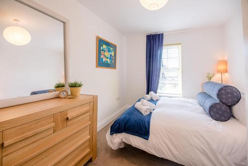 a bedroom with a bed and a large mirror at Rustics, Reydon in Southwold