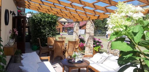 a patio with a wooden pergola and a table and chairs at Ośrodek Wypoczynkowy Karolina in Stegna