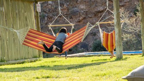 a person sitting on a hammock in a field at Bushman Valley in Prince Albert