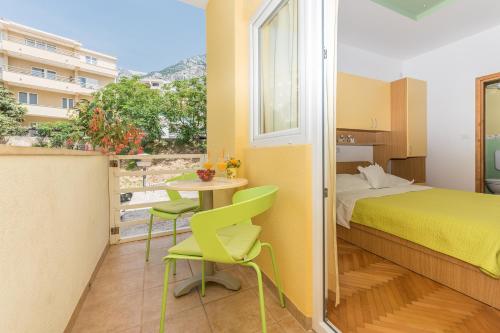a bedroom with a bed and a table and chairs at Apartments Villa Vujcic in Makarska