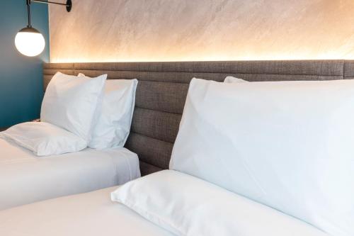 two beds with white pillows sitting next to each other at Novotel Liverpool Paddington Village in Liverpool
