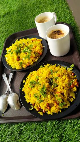 two plates of food on a tray with two cups of coffee at RANGBAARI STAYS & CAFE in Jodhpur