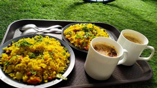 a tray with two plates of food and two cups of coffee at RANGBAARI STAYS & CAFE in Jodhpur