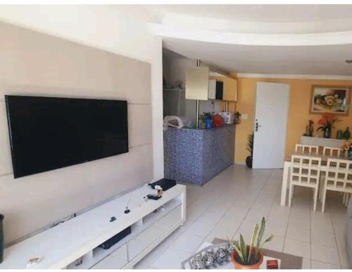 a living room with a large flat screen tv on a wall at Studio Everest Flat vista mar in Recife