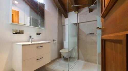 ein Badezimmer mit Toilette und Glasdusche in der Unterkunft Chasa Val Bella in Samnaun
