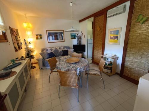 Little Emerald House في مارينا دي بورتيسكو: مطبخ وغرفة معيشة مع طاولة وكراسي
