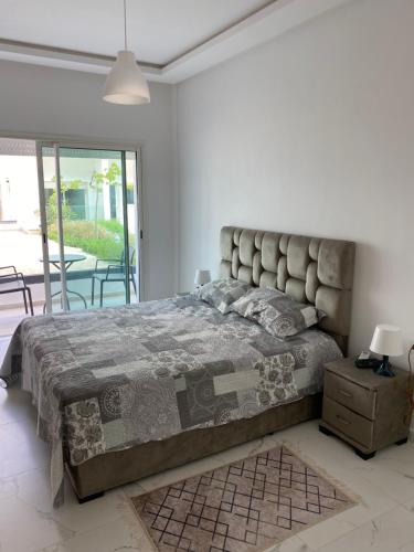 1 dormitorio con 1 cama grande, mesa y sillas en Lovely 4-bedroom condo with pool en Rabat
