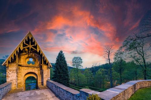a building with a clock on it under a cloudy sky at Schloss Purschenstein in Neuhausen