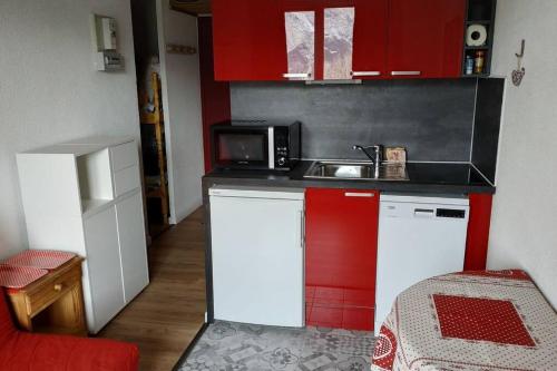 une petite cuisine avec un évier et un micro-ondes dans l'établissement Appartement 4pers Rénové Pied des Pistes - Balcon Vue Montagne, à Puy-Saint-Vincent