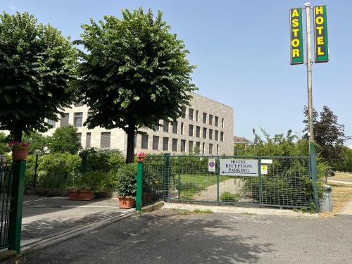 een hek voor een gebouw met een bord bij Hotel Astor in Modena