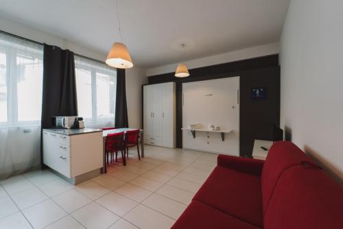 Il comprend un salon avec un canapé rouge et une cuisine. dans l'établissement Mole27 - ResArt, à Turin