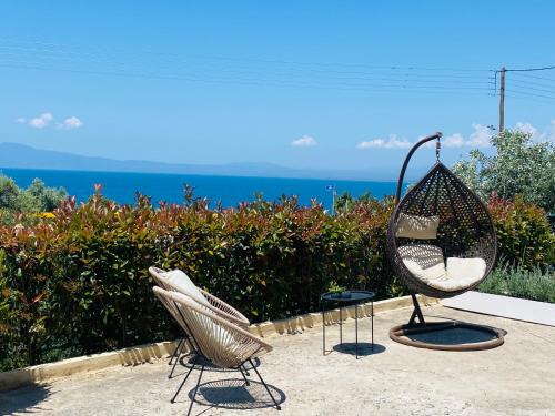 - deux chaises assises sur une terrasse donnant sur l'océan dans l'établissement Almyros Aktis seaview apartment, à Kalamata