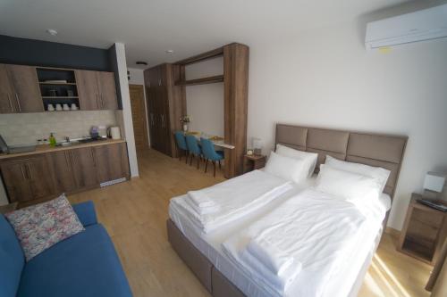 a bedroom with a large white bed and a kitchen at Casa D Argento in Veliko Gradište
