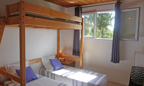 sypialnia z łóżkiem piętrowym i niebieskimi poduszkami w obiekcie Locations "ChezChristine" à Aléria w mieście Aléria