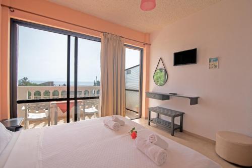 a bedroom with a bed and a large window at Andromaches sea view studio 2 in Achílleion