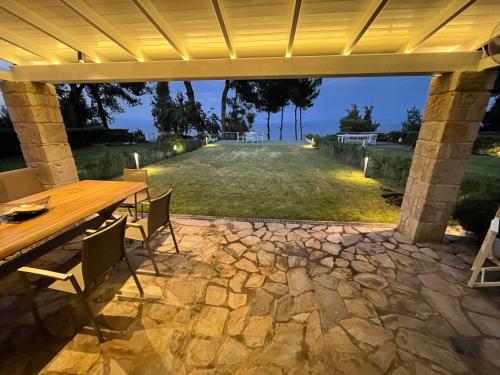 an outdoor patio with a wooden table and chairs at villa ATHINA in Kriopigi