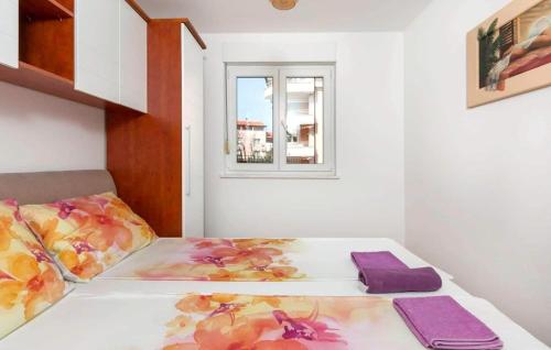 sypialnia z łóżkiem z fioletowymi poduszkami i oknem w obiekcie Apartment Valsaline 2182 w Puli