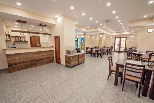 a restaurant with tables and chairs and a bar at Hotel Santa Maria in Obzor