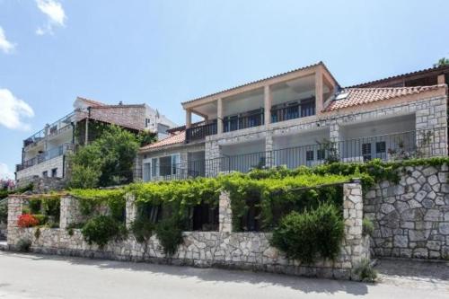 ein Gebäude mit Pflanzen an einer Steinmauer in der Unterkunft Guest House Busurelo in Polače