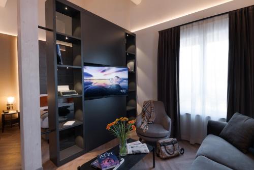 a living room with a couch and a tv at 3T Boutique Hotel in Ivrea