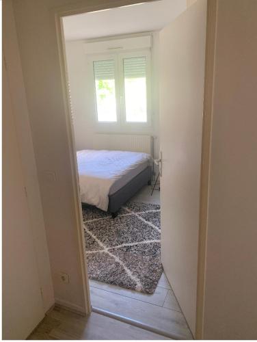 um pequeno quarto com uma cama e uma janela em Disney land Paris - Charmant logement em Bussy-Saint-Georges