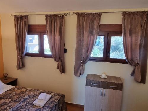 a bedroom with a bed and two windows at Villa Perla with Sea View in Bar