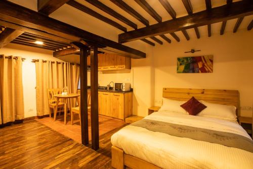 a bedroom with a bed and a kitchen with a table at Patan Wittys hotel in Pātan