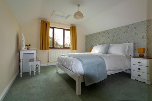 a bedroom with a white bed and a window at Bransford Farm Fishery & B & B in Bransford