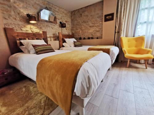 Cette chambre d'hôtel comprend deux lits et une chaise jaune. dans l'établissement Residence La Borde, à Plavilla