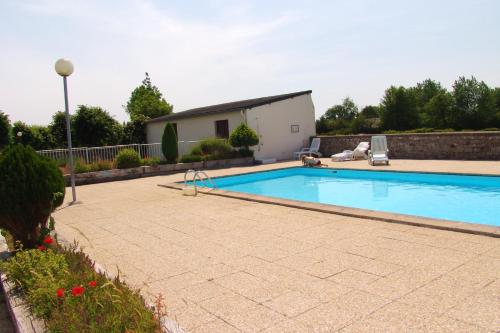 - une grande piscine dans une cour avec une maison dans l'établissement Appartement cosy à Montmartin 27m² avec piscine partagée, à Montmartin-sur-Mer
