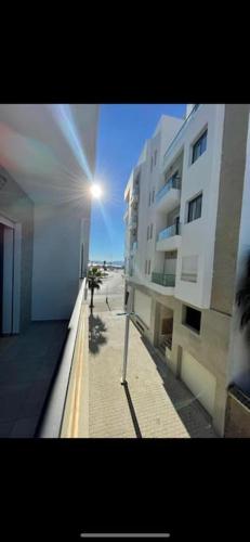 a person walking down a sidewalk next to a building at Luxueux appartement avec vue sur mer à Martil in Martil