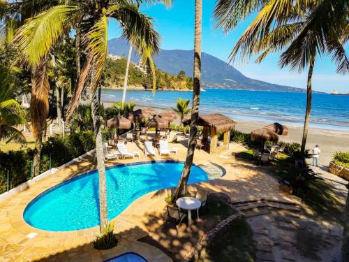 ein Luftblick auf ein Resort mit Pool und Strand in der Unterkunft Barequeçaba Praia Hotel in Barequeçaba