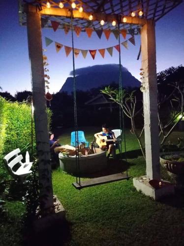 two people sitting on a swing in a gazebo at Serenity1 Homestay in Chiang Dao
