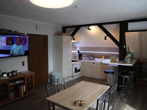 a kitchen with a table and a tv in it at Ferienwohnung Nordstadt in Forst