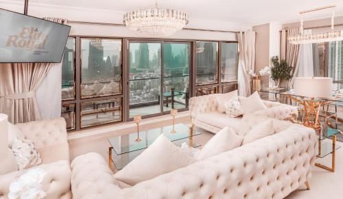 uma sala de estar com mobiliário branco e janelas grandes em Elite Royal Apartment - Panoramic Full Burj Khalifa, Fountain & Skyline view - Imperial - 2 bedrooms & 1 open bedroom without partition em Dubai