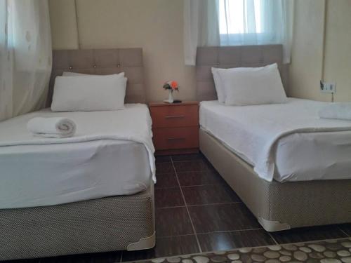 two beds sitting next to each other in a bedroom at MELEK APART PANSİYON in Denizli