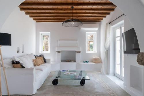 a living room with a white couch and a table at Nefes Residence 2 bedroom villa in Agios Ioannis Mykonos