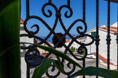 a view of the beach through a fence at Apartment Vranješ in Makarska