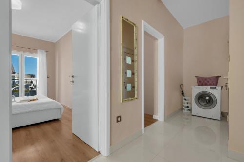 a white room with a bed and a washing machine at Apartment Vranješ in Makarska