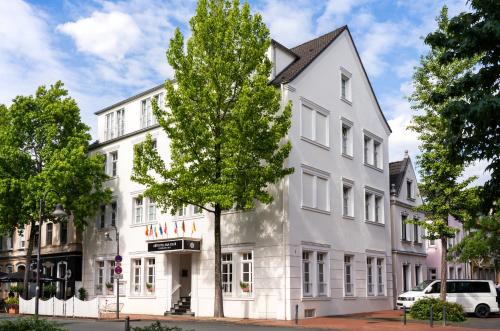a white building with a tree in front of it at Arthotel ANA Fleur in Paderborn