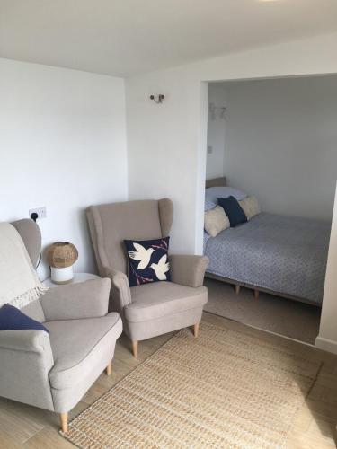 a living room with a chair and a bed at 1-bedroom chalet with parking on site in Looe